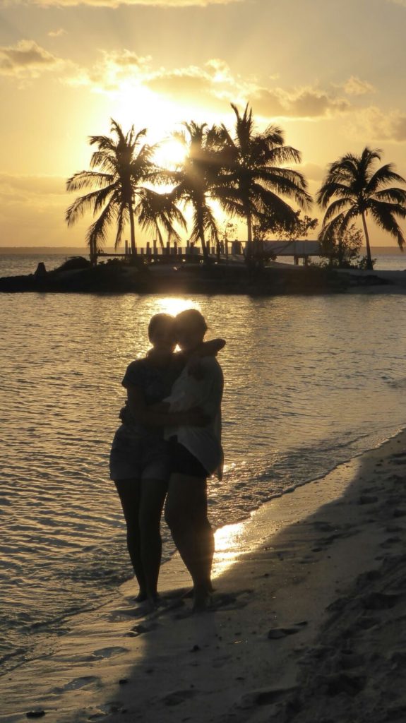 Solnedgang 2 personer strand palmer